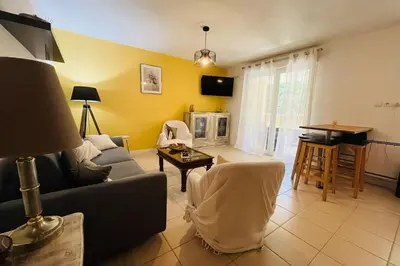a living room with a couch and a table at Le Rimini Terrasse Wifi Parking privé in Narbonne