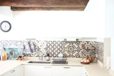 a kitchen with a sink and a tile wall at Gîte Les Tilleuls in Lautrec