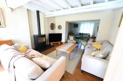 a living room with white couches and a tv at Gîte Les Tilleuls in Lautrec