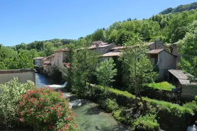 a village in the mountains with a river at Le gîte de Melly in Bélesta