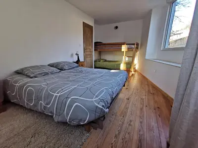 a bedroom with a large bed and a window at Le gîte de Melly in Bélesta