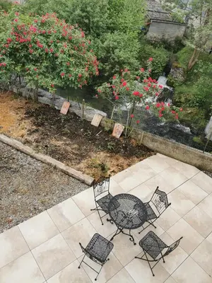 a patio with a table and chairs and flowers at Le gîte de Melly in Bélesta