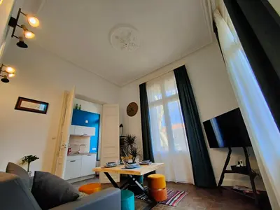 a living room with a couch and a tv at Will's Appart in Narbonne