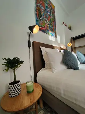 a bedroom with a bed and a table with a potted plant at Will's Appart in Narbonne
