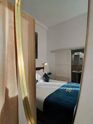 a hotel room with a bed and a mirror at Will's Appart in Narbonne
