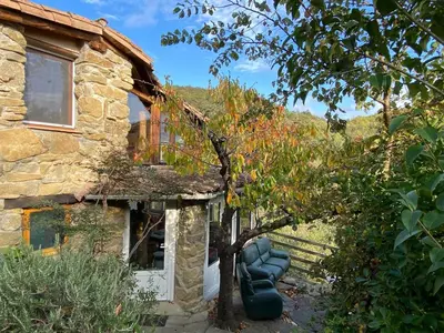 a stone house with a tree in front of it at La bergerie des étoiles in Rouvenac