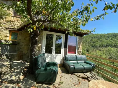 two chairs and a couch in front of a house at La bergerie des étoiles in Rouvenac