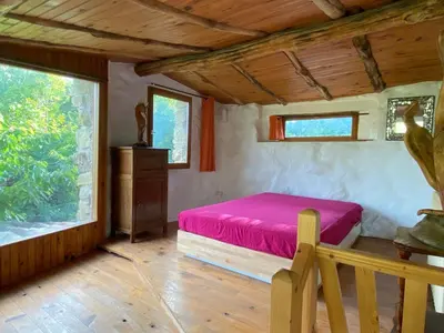 a bedroom with a bed and a wooden floor at La bergerie des étoiles in Rouvenac
