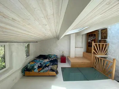 a room with a bed and a staircase in a house at La bergerie des étoiles in Rouvenac
