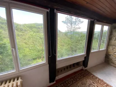 three windows in a room with a view of the forest at La bergerie des étoiles in Rouvenac