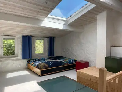 a bedroom with a bed and a skylight at La bergerie des étoiles in Rouvenac