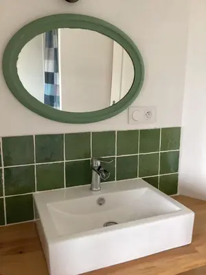 a white sink in a bathroom with a mirror at La Biste in Mirepoix