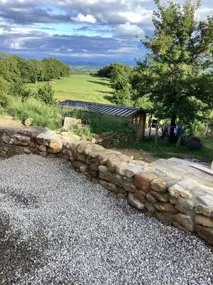 a stone retaining wall in front of a house at La Biste in Mirepoix