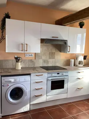 a kitchen with white cabinets and a washing machine at La Biste in Mirepoix