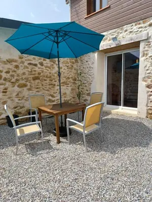 a table with chairs and an umbrella on a patio at La Biste in Mirepoix