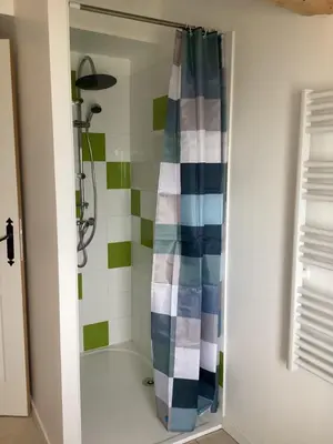 a shower with a blue and white shower curtain at La Biste in Mirepoix