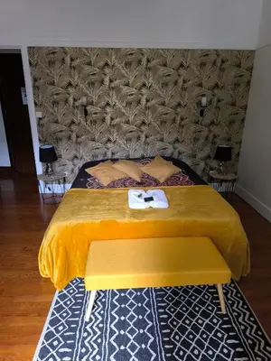 a bedroom with a bed with a yellow comforter at Le lorrain in Saint-Pons-de-Thomières
