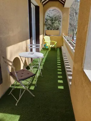 a room with a table and chairs on a balcony at Le lorrain in Saint-Pons-de-Thomières