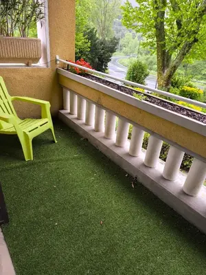 a green chair sitting on a balcony with a window at Le lorrain in Saint-Pons-de-Thomières