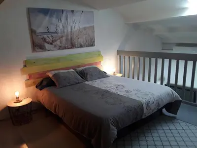 a bedroom with a bed with a painting on the wall at Grand studio au milieu des vignes in Moussan
