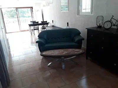 a living room with a green couch and a table at Grand studio au milieu des vignes in Moussan