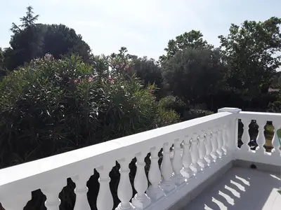 a white fence with trees and bushes at Grand studio au milieu des vignes in Moussan