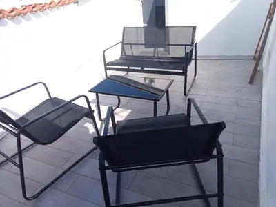 a group of chairs and tables on a balcony at T3 Terrasse vue Cathédrale Climatisé in Narbonne