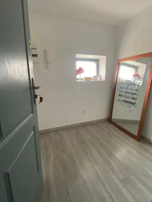 an empty room with a wooden floor and a door at T3 Terrasse vue Cathédrale Climatisé in Narbonne