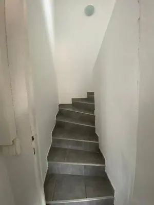 a stairway with a stair case in a room at T3 Terrasse vue Cathédrale Climatisé in Narbonne