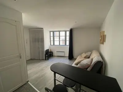 a living room with a couch and a window at Studio Cosy Climatisé Centre Ville faites tout à Pied in Narbonne