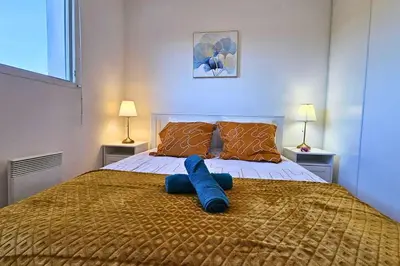a bed with a blue object on top of it at L'évasion Carcassonnais avec Terrasse 2 places de Parking privée in Carcassonne