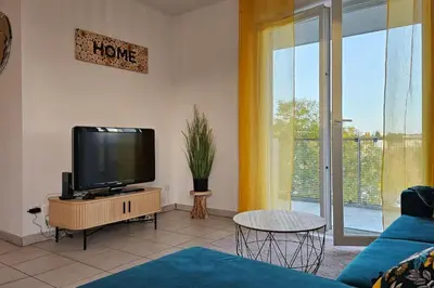 a living room with a flat screen tv on a cabinet at L'évasion Carcassonnais avec Terrasse 2 places de Parking privée in Carcassonne