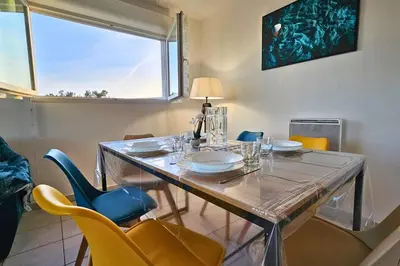 a dining room with a table with chairs and a window at L'évasion Carcassonnais avec Terrasse 2 places de Parking privée in Carcassonne