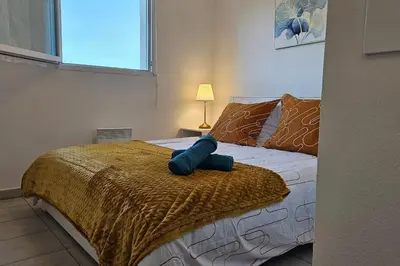 a bedroom with a bed with a blue pillow on it at L'évasion Carcassonnais avec Terrasse 2 places de Parking privée in Carcassonne