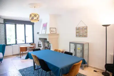 a living room with a blue table and chairs at L'Onde des berges de l'Aude in Carcassonne