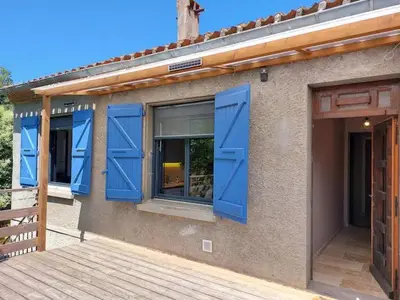 a building with blue doors and a wooden deck at L'Onde des berges de l'Aude in Carcassonne