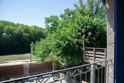a balcony with a fence and a tree at L'Onde des berges de l'Aude in Carcassonne