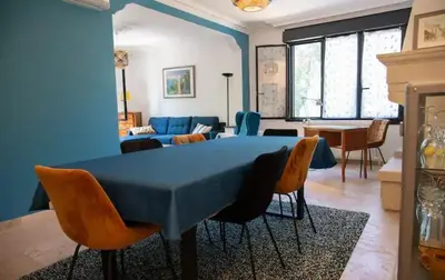 a living room with a blue table and chairs at L'Onde des berges de l'Aude in Carcassonne