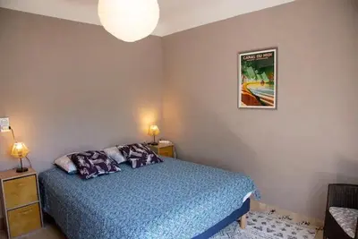 a bedroom with a bed and a picture on the wall at L'Onde des berges de l'Aude in Carcassonne