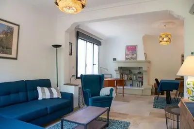a living room with a blue couch and chairs at L'Onde des berges de l'Aude in Carcassonne