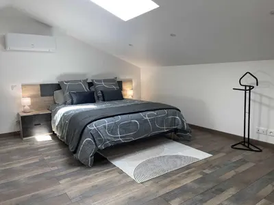 a bedroom with a large bed and a skylight at La detente in Lézignan-Corbières