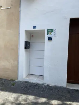 a white door with a sign on the side of a building at La detente in Lézignan-Corbières