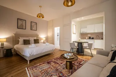a bedroom with a bed and a living room at L'Impérium Suite - Les Halles - Narbonne in Narbonne