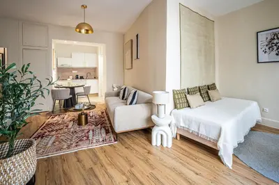 a living room with a bed and a couch at L'Impérium Suite - Les Halles - Narbonne in Narbonne