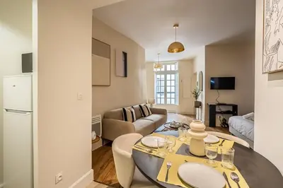 a living room with a table and a couch at L'Impérium Suite - Les Halles - Narbonne in Narbonne