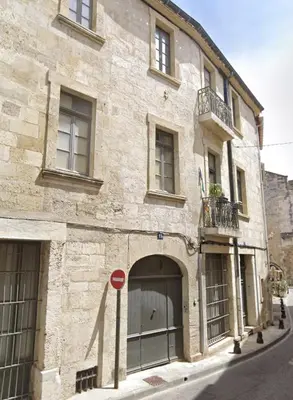 a building on a street with a red stop sign in front at L'Impérium Suite - Les Halles - Narbonne in Narbonne