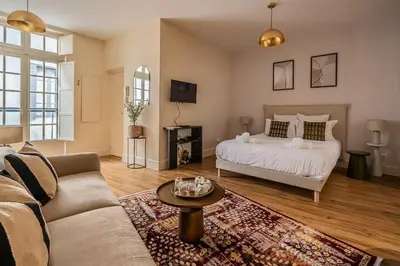 a living room with a bed and a couch at L'Impérium Suite - Les Halles - Narbonne in Narbonne