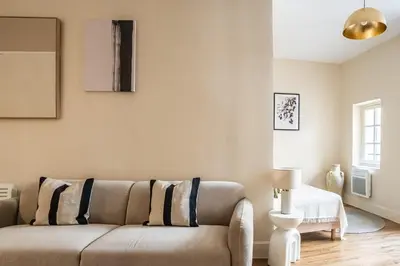 a living room with a couch and a table at L'Impérium Suite - Les Halles - Narbonne in Narbonne