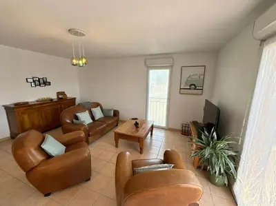 a living room with leather furniture and a tv at L'Escapade Cathare - Résidence Terrasse & parking in Carcassonne