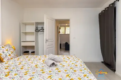 a bedroom with a large bed with a comforter at Le cocon centre ville au calme Oc Keys 34 in Castelnaudary